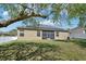 Home's rear view featuring a well-maintained lawn, screened lanai, and solar panels at 5832 Tarleton Way, Mount Dora, FL 32757