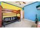 Vibrant bedroom featuring a bunk bed with a futon underneath and brightly colored walls at 5832 Tarleton Way, Mount Dora, FL 32757