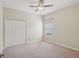 Neutral bedroom with a ceiling fan, a window with blinds, and a closet with double doors at 5832 Tarleton Way, Mount Dora, FL 32757