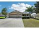Charming one-story home with a manicured lawn and a three-car garage and mature trees at 5832 Tarleton Way, Mount Dora, FL 32757