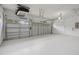 A spacious two-car garage with pristine white walls and ample lighting at 5832 Tarleton Way, Mount Dora, FL 32757