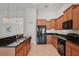 Modern kitchen with granite countertops, stainless steel sink, and wood cabinetry at 5832 Tarleton Way, Mount Dora, FL 32757