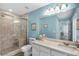 Modern bathroom featuring a large shower with a built-in seat, white vanity and blue walls at 631 Reserve Dr, Davenport, FL 33896