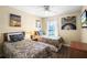 Bedroom featuring two twin beds, hardwood floors, a window with blinds and colorful wall art at 631 Reserve Dr, Davenport, FL 33896