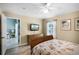 Cozy bedroom featuring light hardwood floors, a ceiling fan, and an ensuite bathroom entrance at 631 Reserve Dr, Davenport, FL 33896