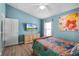 Cozy bedroom with a wall mounted TV, wooden dresser, colorful bedding and wood-look floors at 631 Reserve Dr, Davenport, FL 33896