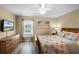 Bright bedroom featuring a queen bed, dresser, side tables and artwork on the walls at 631 Reserve Dr, Davenport, FL 33896