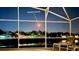 Screened patio view overlooking a lake with a rocket launch in the background near this beautiful Florida home at 631 Reserve Dr, Davenport, FL 33896