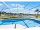 Inviting pool within a screened enclosure, offering serene views of the pond and neighborhood landscape at 631 Reserve Dr, Davenport, FL 33896