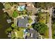 Stunning aerial view of a lakeside property with pool, dock, and lush landscaping at 7841 Georgeann St, Winter Park, FL 32792