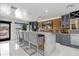 Stylish bar area with concrete counter, wood backsplash, gray cabinets and wine refrigerator at 7841 Georgeann St, Winter Park, FL 32792