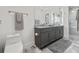 Bathroom featuring double vanity, marble floors, gray cabinets, large mirror and a glass-enclosed shower at 7841 Georgeann St, Winter Park, FL 32792