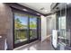 Modern bathroom featuring a glass shower and sliding glass doors that open to a balcony with waterfront views at 7841 Georgeann St, Winter Park, FL 32792