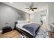 Modern bedroom with hardwood floors, gray walls, ceiling fan, and a king size platform bed with gray and white comforter at 7841 Georgeann St, Winter Park, FL 32792