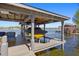 Covered boat lift featuring patio furniture with water view on a sunny day at 7841 Georgeann St, Winter Park, FL 32792