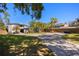 Lush landscaping and a circular driveway complement the modern exterior of this two-story home with a grey brick driveway at 7841 Georgeann St, Winter Park, FL 32792