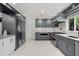 Modern kitchen with stainless steel appliances, gray cabinets, and white countertops, showcasing a clean and functional design at 7841 Georgeann St, Winter Park, FL 32792
