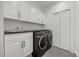 Well-equipped laundry room featuring modern washer/dryer, subway tile backsplash, and ample cabinet storage at 7841 Georgeann St, Winter Park, FL 32792