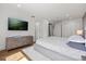 Bright main bedroom featuring wood floors, a dresser, and a television mounted to the wall at 7841 Georgeann St, Winter Park, FL 32792