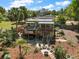 Aerial view of the home featuring a deck, outdoor seating, lush landscaping, and a welcoming firepit area at 809 Poinsettia Dr, Eustis, FL 32726