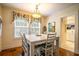 Bright dining room featuring a charming chandelier, large windows, and stylish white dining set at 809 Poinsettia Dr, Eustis, FL 32726