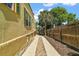 A concrete driveway is nestled between a stucco house and a wooden fence at 809 Poinsettia Dr, Eustis, FL 32726