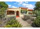 Inviting home featuring red accents, green shutters, and a meticulously landscaped front yard with mature plants at 809 Poinsettia Dr, Eustis, FL 32726