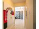 Hallway with neutral walls, tile flooring, art, and gray doors at the end of the hallway at 809 Poinsettia Dr, Eustis, FL 32726