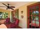 Charming porch with red tile flooring, ceiling fan, and cozy seating at 809 Poinsettia Dr, Eustis, FL 32726