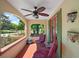 Cozy covered front porch featuring red tile flooring, two chairs, and decorative wall planters at 809 Poinsettia Dr, Eustis, FL 32726