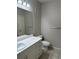 Neat bathroom with white vanity, elongated toilet, large mirror, and a tiled floor that creates a clean and refreshing space at 860 N Orange Ave # 149, Orlando, FL 32801