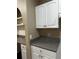 Granite countertops, white cabinetry, and a built-in arched desk nook creates an efficient and stylish kitchen area at 860 N Orange Ave # 149, Orlando, FL 32801