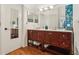 Bathroom featuring double vanity, wood cabinets, dual mirrors, and a separate door at 1120 Parker Canal Ct, Oviedo, FL 32765