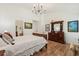 The primary bedroom features hardwood floors, chandelier, and a vintage dresser at 1120 Parker Canal Ct, Oviedo, FL 32765