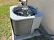 Exterior air conditioning unit surrounded by grass, showcasing the home's climate control system at 124 Harrison Rd, Daytona Beach, FL 32118