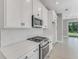 Modern kitchen with white cabinetry, stainless steel appliances, and herringbone backsplash at 1276 Jackson Hole Ct, Deland, FL 32724
