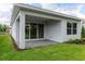 Covered patio with brick floor and sliding glass doors to the backyard and manicured lawn at 1276 Jackson Hole Ct, Deland, FL 32724