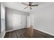 Neutral bedroom with dark wood flooring, a ceiling fan, and a large closet with white doors at 13087 Salk Way, Orlando, FL 32827
