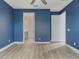 A spacious bedroom with light wood floors, blue walls, and a ceiling fan at 13087 Salk Way, Orlando, FL 32827