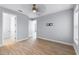 Light-filled bedroom with wood-look flooring, neutral walls, ceiling fan, and white trim at 13087 Salk Way, Orlando, FL 32827