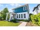 This two-story home features a blue exterior with a covered front porch and well-manicured lawn at 13087 Salk Way, Orlando, FL 32827