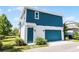 This two-story home features a blue exterior with a matching blue garage door and front door at 13087 Salk Way, Orlando, FL 32827
