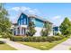 Corner lot featuring a blue two-story home with pristine landscaping, and a sidewalk at 13087 Salk Way, Orlando, FL 32827