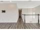 A hallway with hardwood floors, white walls, and a dark wood railing at 13087 Salk Way, Orlando, FL 32827