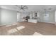 Bright and open floor plan featuring light wood flooring, a ceiling fan, and a view into the kitchen at 13087 Salk Way, Orlando, FL 32827