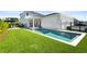 Gorgeous backyard featuring a modern pool, manicured lawn, and outdoor lounge space at 14004 Gullstrand Ave, Orlando, FL 32827