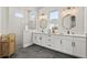 A modern bathroom features dual vanities, sleek fixtures, and a glass-enclosed shower with gray tile at 14004 Gullstrand Ave, Orlando, FL 32827