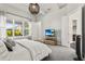 Bright main bedroom features a pendant light, a TV set, and a view of a patio with outdoor furniture at 14004 Gullstrand Ave, Orlando, FL 32827