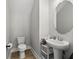 A cozy powder room features a pedestal sink, a toilet, and a framed mirror with a shelf at 14004 Gullstrand Ave, Orlando, FL 32827