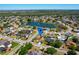 Aerial view showcases a neighborhood featuring lush greenery, a serene pond, and well-maintained single-Gathering homes at 14901 Wild Wood Lily Ct, Orlando, FL 32824